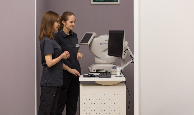 Два лікарі-офтальмологи працюють із сучасним діагностичним обладнанням