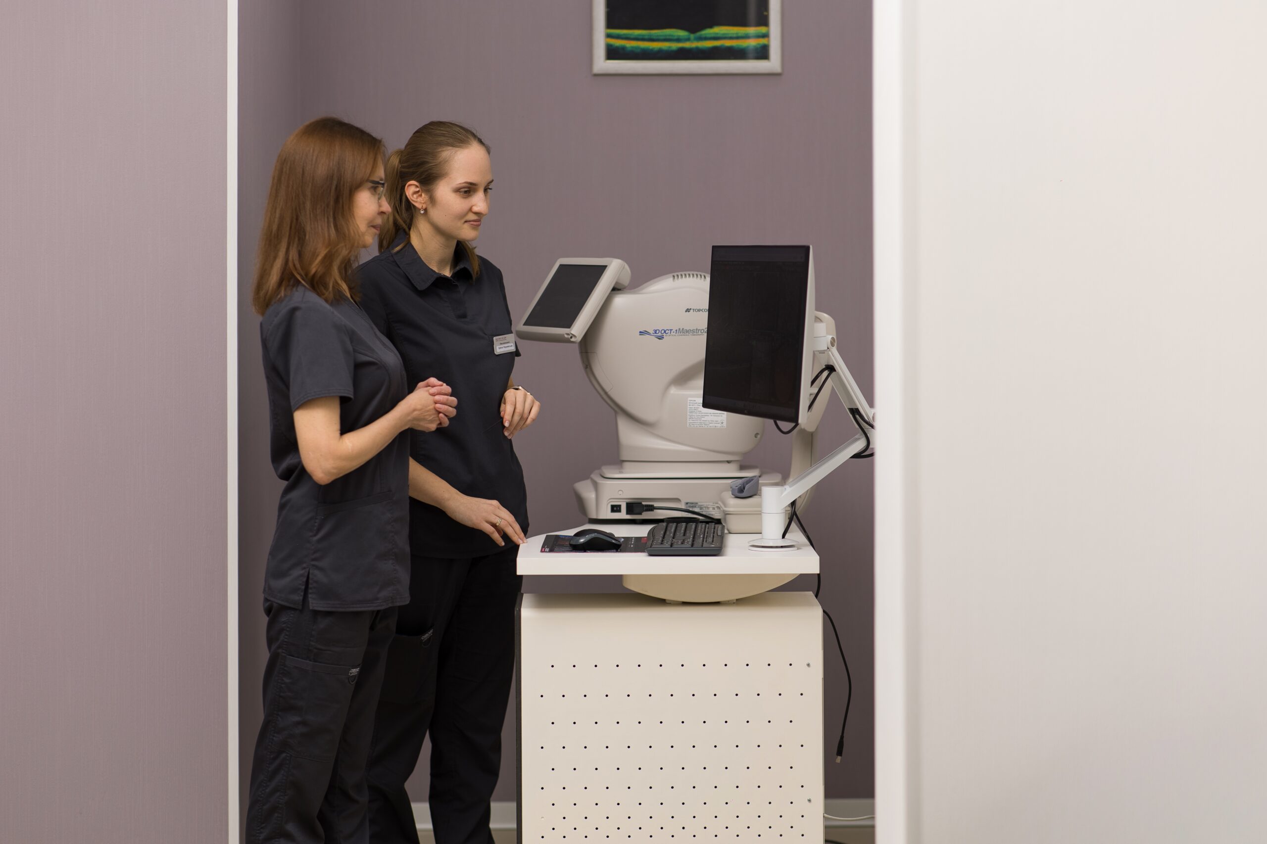 Два лікарі-офтальмологи працюють із сучасним діагностичним обладнанням