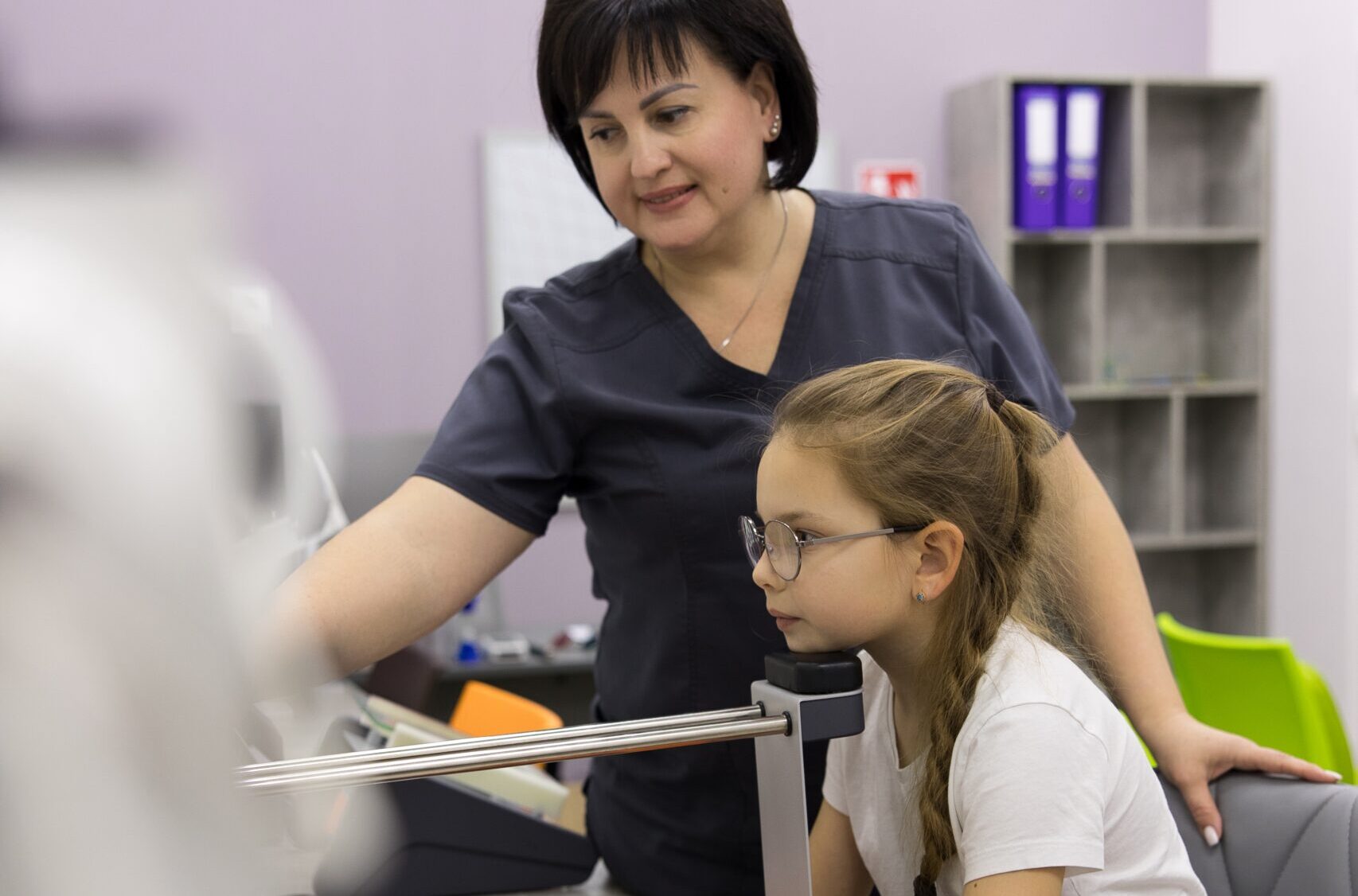 Дитина на прийомі у дитячого офтальмолога під час огляду зору в клініці