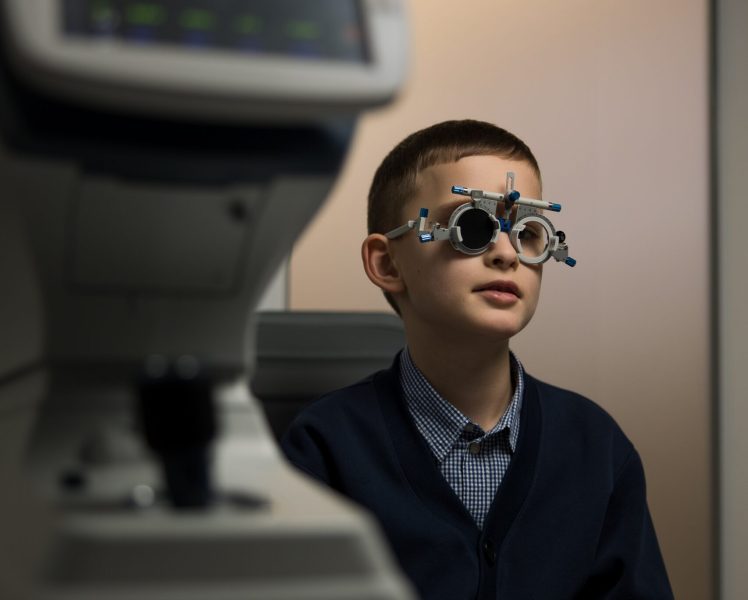 Дитина на прийомі у дитячого офтальмолога під час огляду зору в клініці