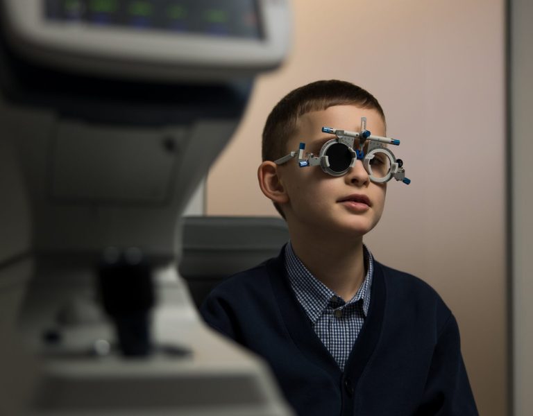 Дитина на прийомі у дитячого офтальмолога під час огляду зору в клініці