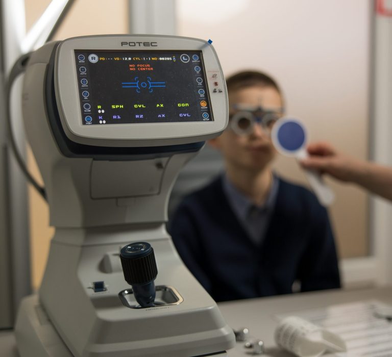 Дитина на фоні сучасного офтальмологічного обладнання під час обстеження зору