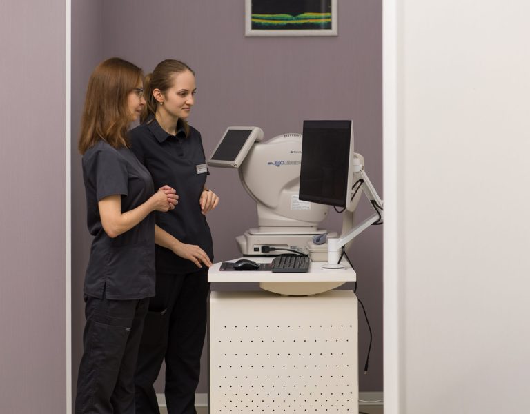 Два лікарі-офтальмологи працюють із сучасним діагностичним обладнанням