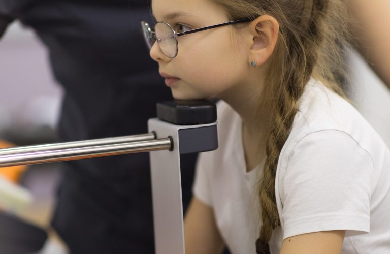 Перевірка зору у дитини під час огляду в дитячого офтальмолога в клініці